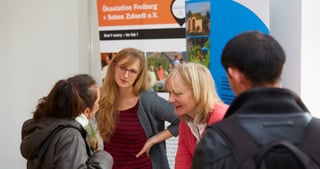 Young people talking at the exhibition stand of Ökostation Freiburg and Solare Zukunft e.V.