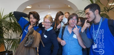 Young people posing for a photo in a foyer with plants, one wearing a blue Engajamundo shirt