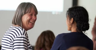 Two women laughing during a conversation