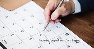 Hand marking a date in a calendar with a pen. Photo by rawpixel.com from Pexels