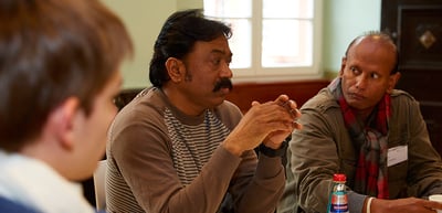 Two laureates listening at a round table