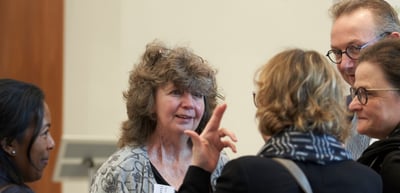 Convention participants talking in a group, one woman gesturing as she speaks