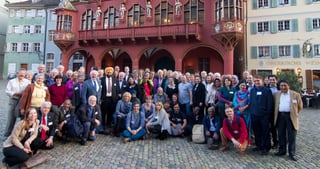 Group photo of the participants of the 3rd convention on a square in front of the red Historisches Kaufhaus in Freiburg
