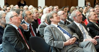 Audience in a full hall listening attentively