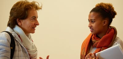Older woman and young woman with an orange scarf in conversation