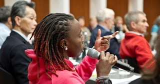 Participant speaking into a microphone during a discussion at the convention