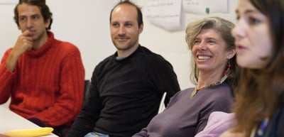 Participants listening and smiling during a discussion