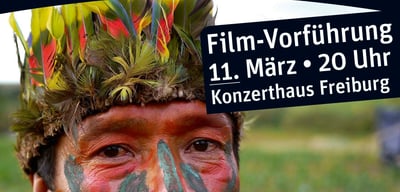 Detail of a flyer with an indigenous man with face paint and a feather headdress, the text reads "Film-Vorführung 11. März, 20 Uhr, Konzerthaus Freiburg"