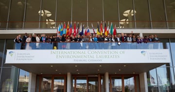 Participants of the 6th ICEL with national flags on a balcony above a banner reading International Convention of Environmental Laureates, Freiburg Germany