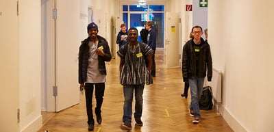Three participants walking down a school corridor