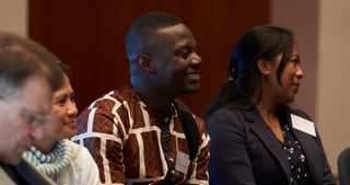 Smiling participants seated in the audience