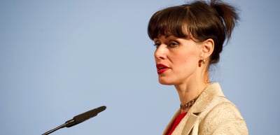 Woman with dark hair speaking into a microphone