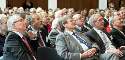 Audience in a full hall listening attentively