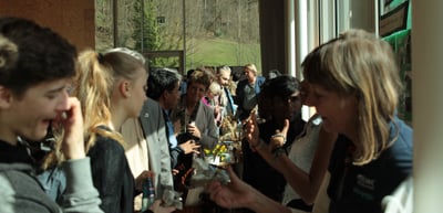Young people gathered closely around an exhibition table