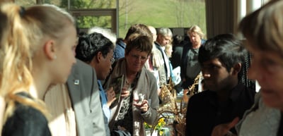 Young visitors and laureates crowding around an exhibition table