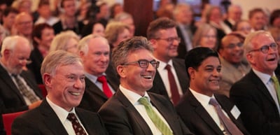 Smiling audience in the front rows of a hall