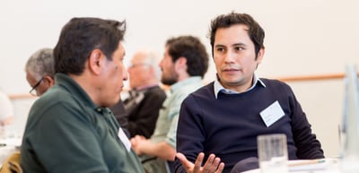 Participants talking at a table during a discussion round