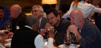 Participants talking over wine at a dinner table