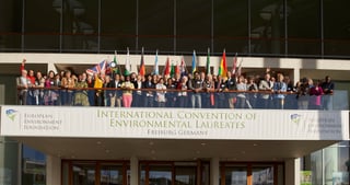 Group photo of the participants with national flags on the balcony of the Konzerthaus Freiburg above a banner: European Environment Foundation, International Convention of Environmental Laureates, Freiburg Germany