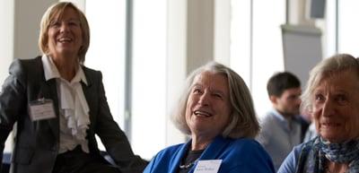 Three women smiling in the audience
