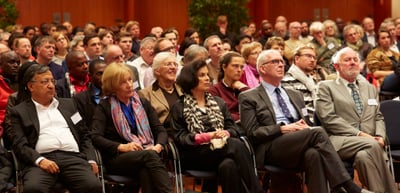 Audience seated in rows in a large hall