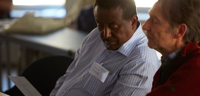 Two men listening at a seminar table