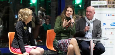 Sarah Wiener speaking into a microphone in a talk with a woman and a man on stage at the Green Dinner