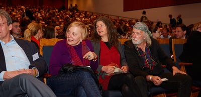 Audience in the front rows of the concert hall in conversation