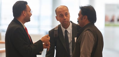 Three men in conversation in a foyer