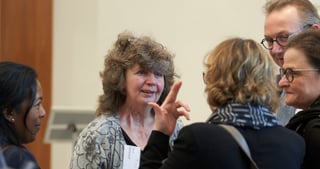 Convention participants talking in a group, one woman gesturing as she speaks