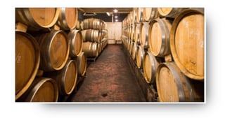 Wine barrels in a long cellar of the winery Dr. Heger