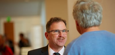 Smiling man with glasses talking with a woman