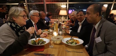 Participants eating together at a long table in a restaurant