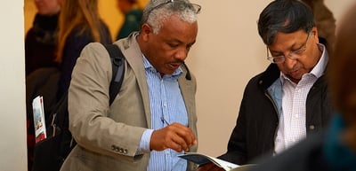 Two laureates looking at a programme booklet together