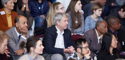 Audience of young and older participants seated on steps