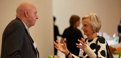 Older woman gesturing while talking with an older man