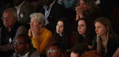 Laureates and students listening attentively in the audience