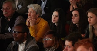 Young and older members of the audience watching attentively