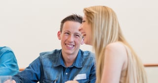 Smiling young man listening to a young woman with long blond hair