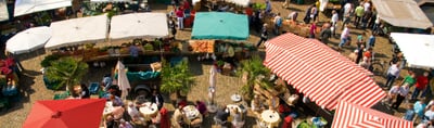 Farmers market with stalls and parasols in Freiburg, seen from above