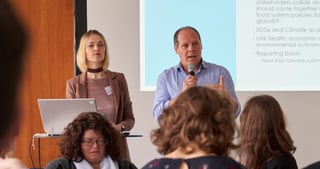 Two speakers presenting the UN Environment Food Workshop in front of a projected slide