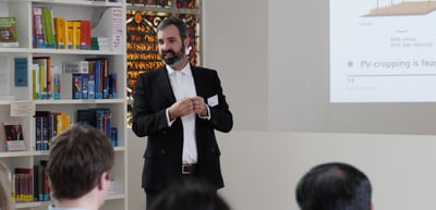 A speaker in a library room presenting a slide about PV cropping