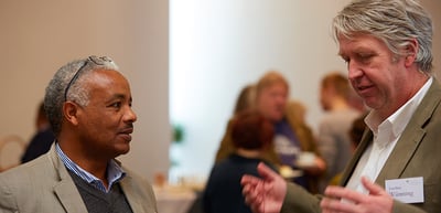 Two men talking, one gesturing with his hands