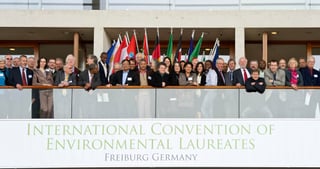 Participants on a balcony above a banner reading International Convention of Environmental Laureates, Freiburg Germany