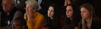 Audience listening to a public lecture in a dark hall