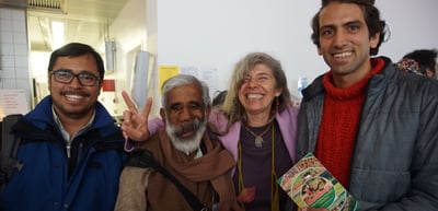 Four smiling participants posing for a photo, one making a victory sign