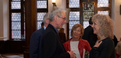 Participants talking in a hall with leaded glass windows in the Historisches Kaufhaus