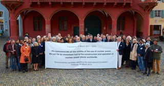 Environmental laureates in front of the red Historisches Kaufhaus in Freiburg holding a banner: "Fukushima, 11 March 2011-2015. We commemorate all the victims of the use of nuclear power. We call for an immediate halt to the construction and operation of nuclear power plants worldwide. Environmental Laureates attending the International Convention, Freiburg, 12 March 2015"