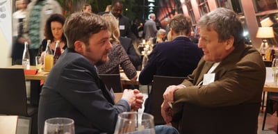 Two men talking at a table in a restaurant