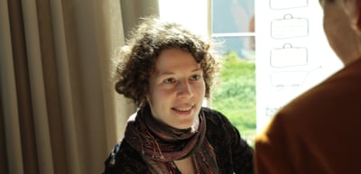 Smiling young woman with curly hair and a scarf
